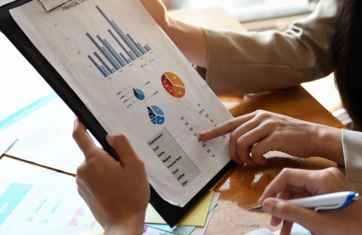 A person holding a book using data analytics reports & results to make business successful. Get data analytics insights for your business